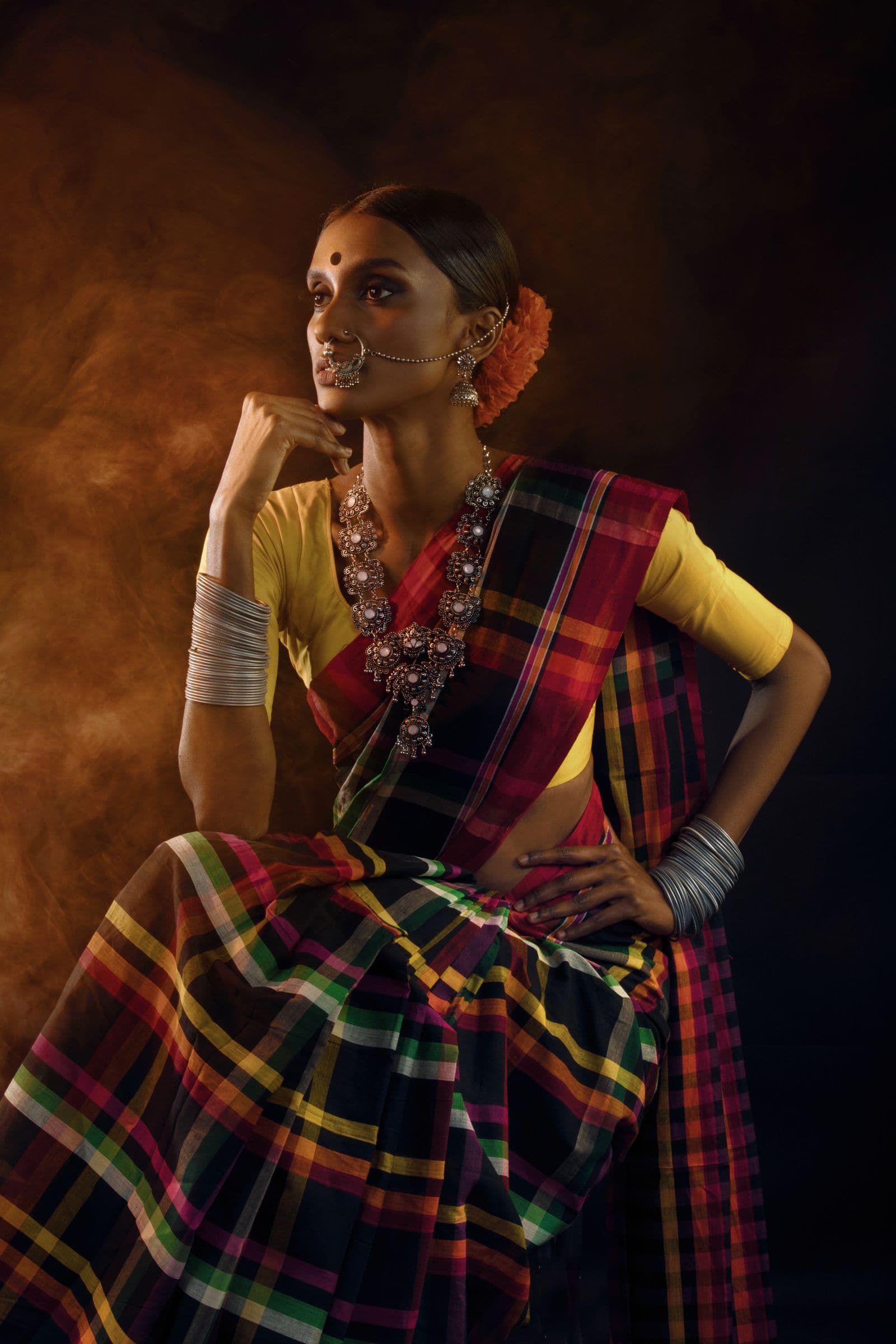 Model wearing a multicoloured checked saree with silver jewellery